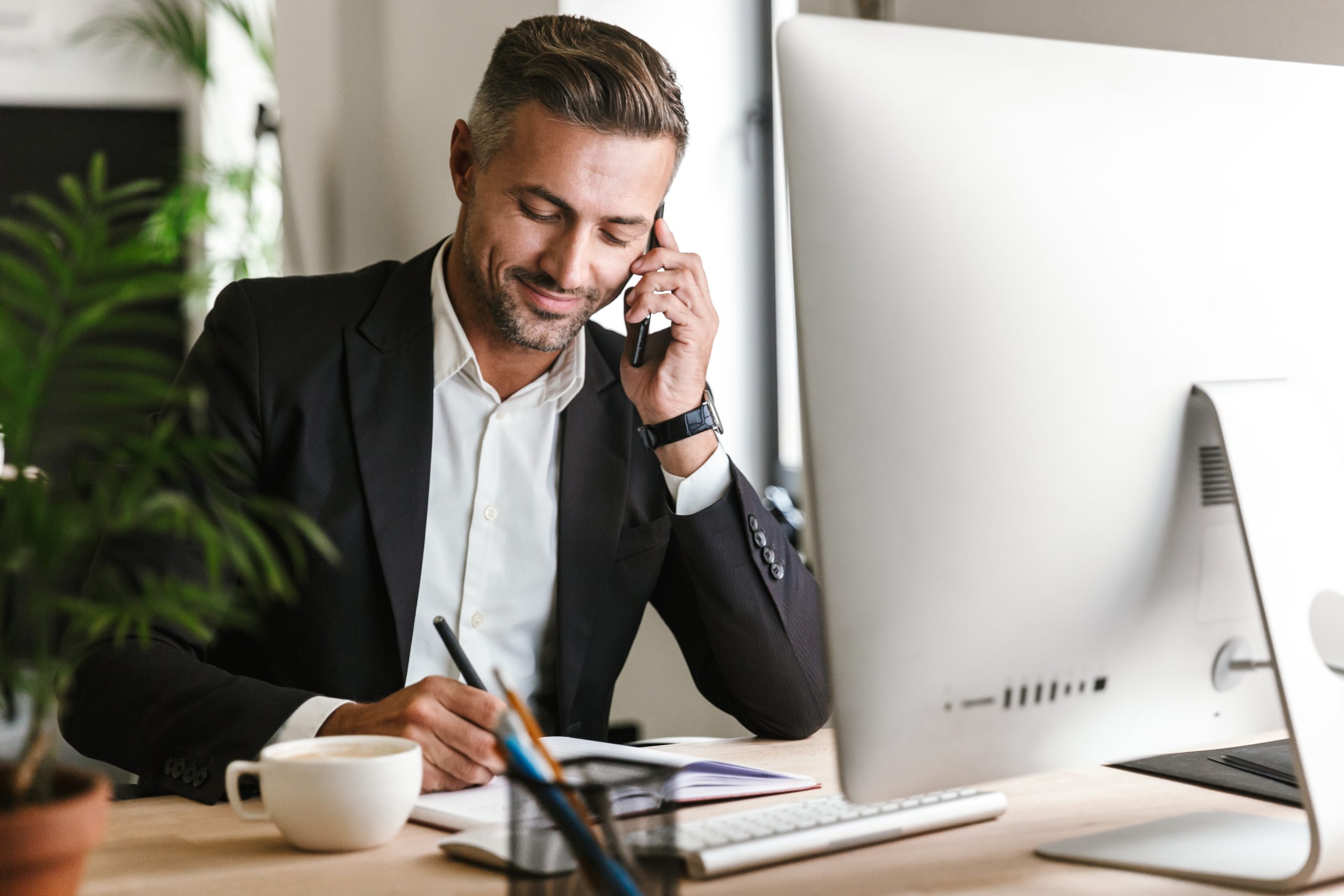Businessman talking on cell phone while working